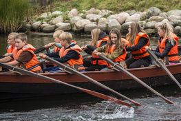 Der bliver roet i takt og skoleeleverne har det sjovt, imens de ror.